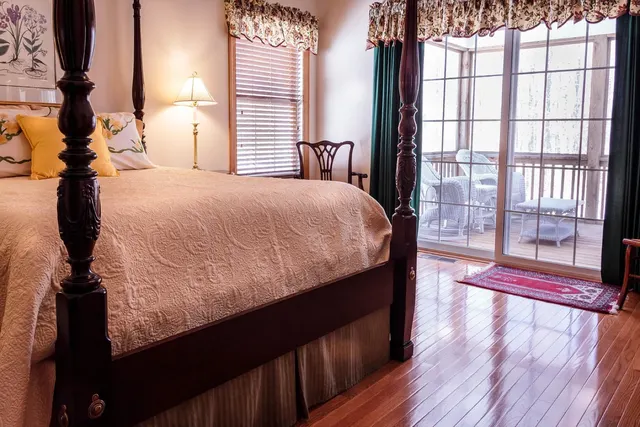 Full-height curtains drawn to one side of a wide sliding glass door onto a garden.