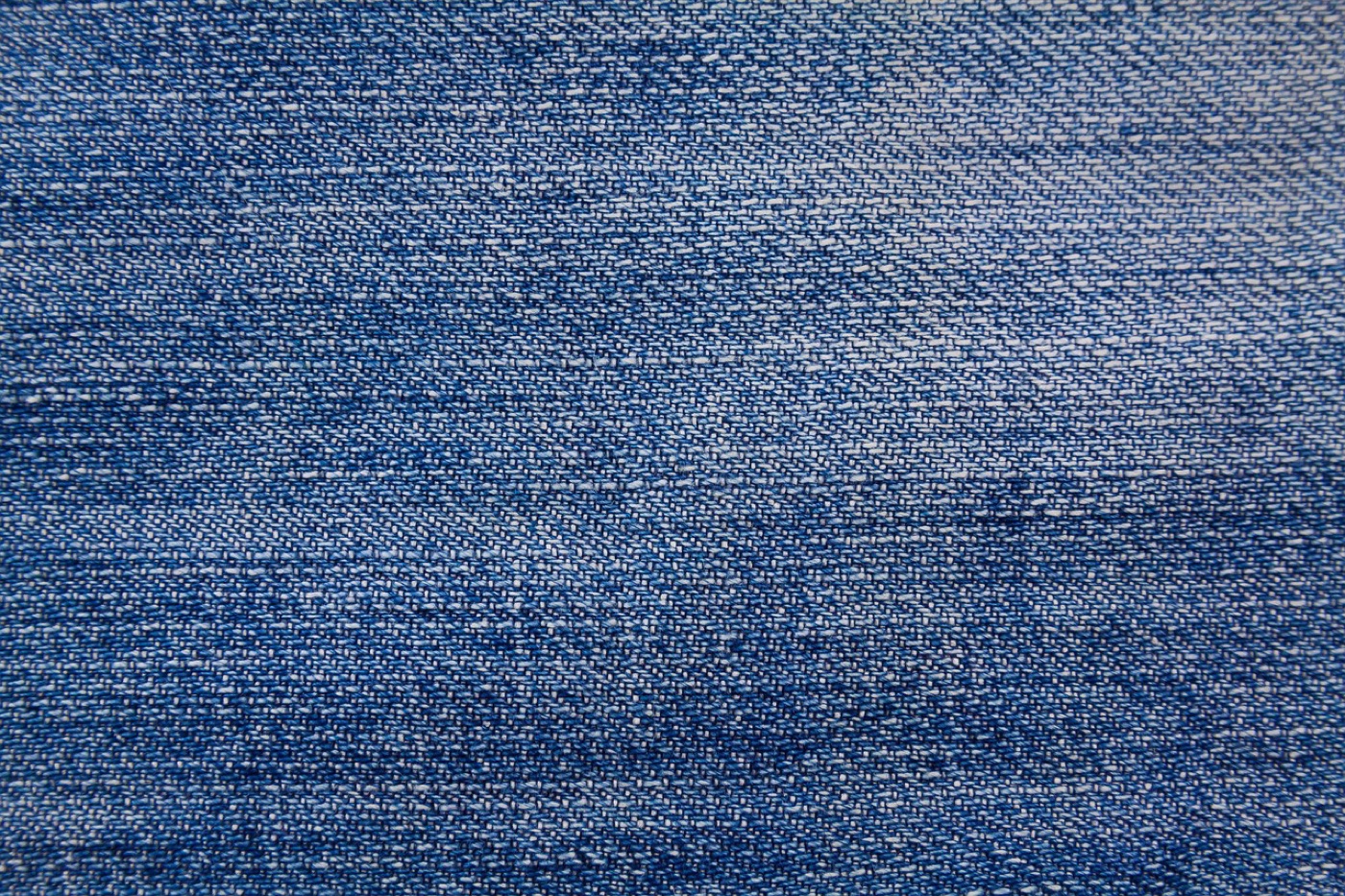 A close view of a flatwoven rug surface in blue and off-white, showing the interlaced warp and weft threads of the weave.