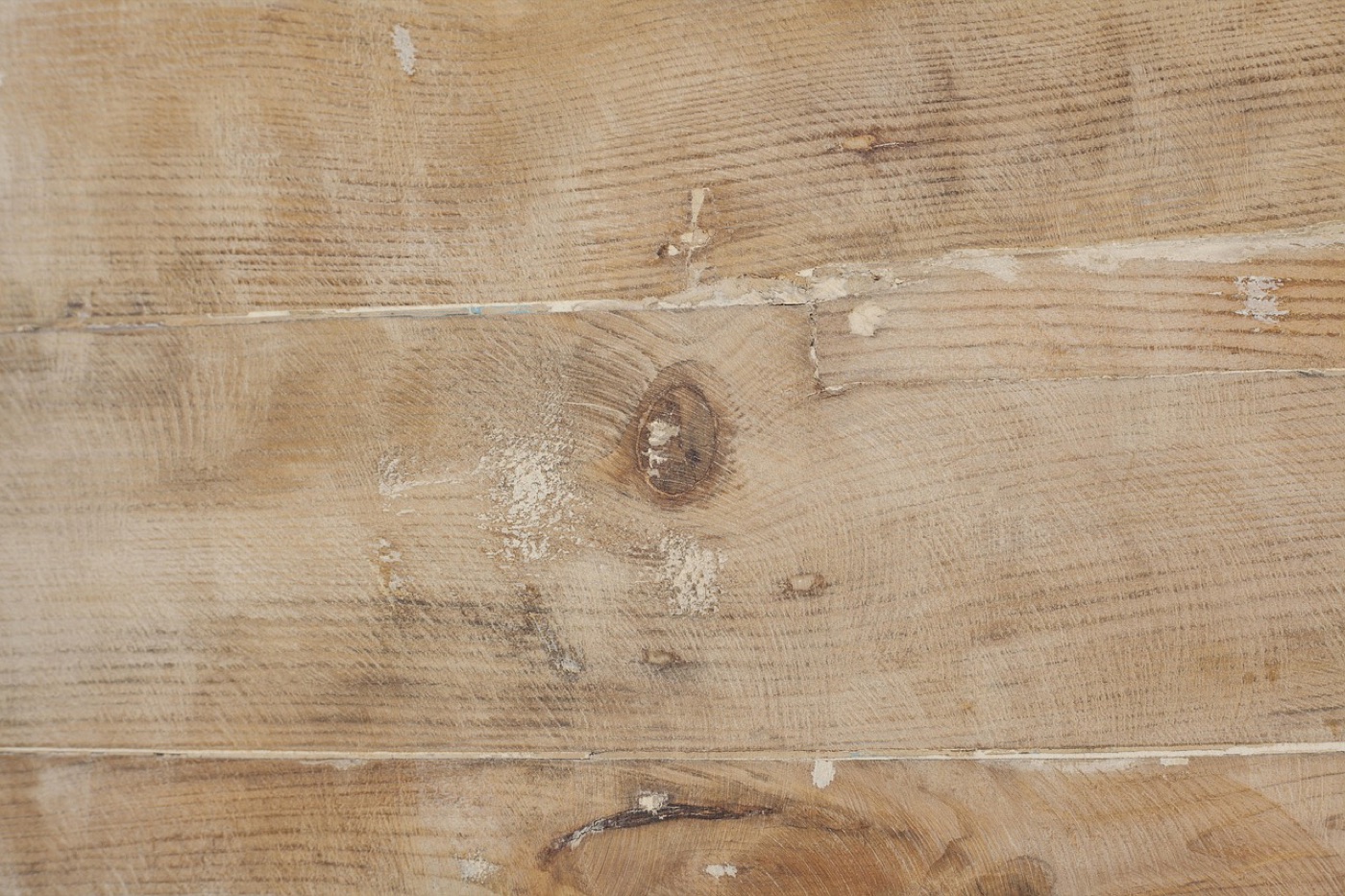 One corner of a rug lifted back to show the non-slip pad underneath and the line where the pad meets the floor.