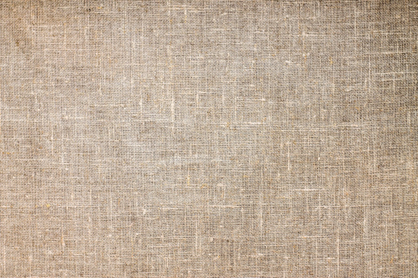 A pale viscose rug with a soft sheen lying on a wooden floor, photographed at an angle that shows the fibre direction.